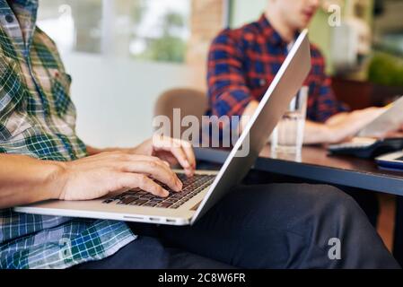 Close-up image of universiry students working on laptop when sitting at local cafe Stock Photo