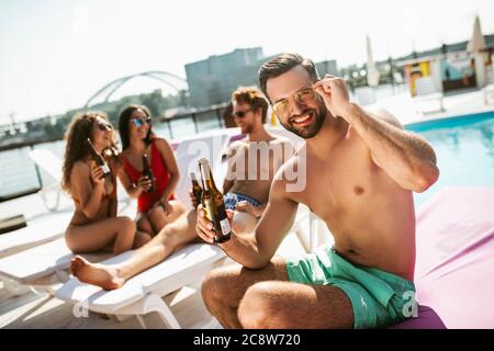 Group of young people having good time near the swimming pool Stock Photo
