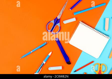 School supplies on blue and orange background. Education concept. Stock Photo