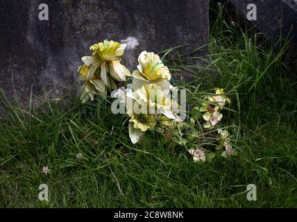 Artificial flowers on a grave, UK Stock Photo