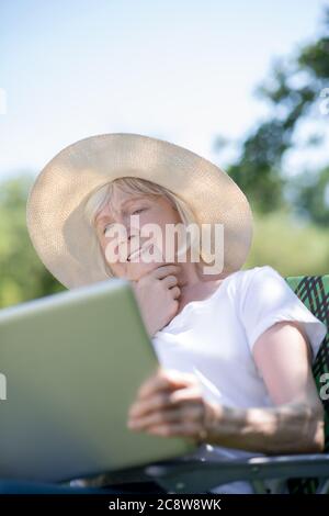 Thoughtful elderly woman having a rest with her computer Stock Photo