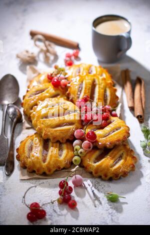 Fruit cookies stuffed with apple.Morning coffee.Sweet red currant.Healthy food and drink. Stock Photo