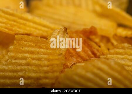 Corrugated potato chips, the texture of the surface. Close up Stock Photo