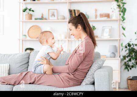 Happy loving family. Mother and her toddler baby boy playing at home