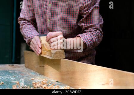 Female carpenter working in carpenter's shop with wood planer. DIY, woodwork concept. Stock Photo