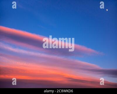 Beautiful colorful clouds at sunset with a moon in the corner of the image Stock Photo