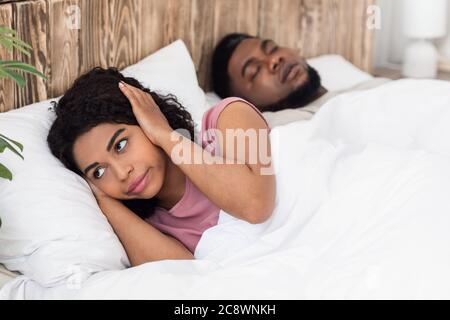 Balck woman suffering from her snoring boyfriend Stock Photo