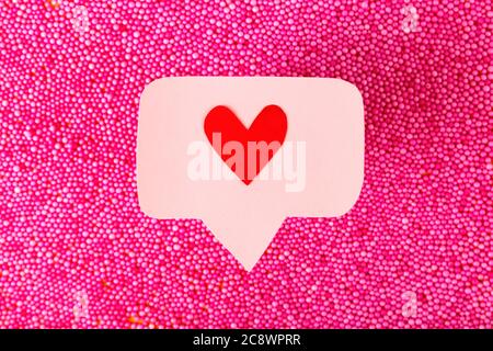 Social media promotion success concept. Pink heart-shaped emoji Stock Photo