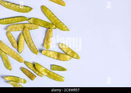 Frozen vegetables such as pea pods on a blue background. Copy space. Top view. Horizontal orientation Stock Photo