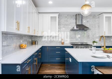 https://l450v.alamy.com/450v/2c8wrgg/a-luxurious-white-and-blue-kitchen-with-gold-hardware-bosch-and-samsung-stainless-steel-appliances-and-white-marbled-granite-counter-tops-2c8wrgg.jpg