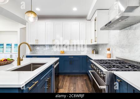A luxurious white and blue kitchen with gold hardware, Bosch and Samsung  stainless steel appliances, and white marbled granite counter tops Stock  Photo - Alamy