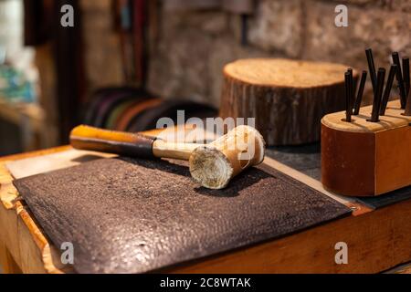 Closeup of tools of a leather craftsman in beautiful traditional workshop Stock Photo