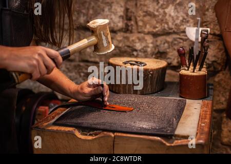 Closeup of hands o a leather craftswoman producing a hand-made belt Stock Photo
