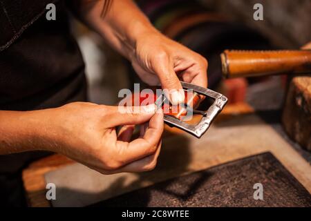 Closeup of hands o a leather craftswoman producing a hand-made belt Stock Photo