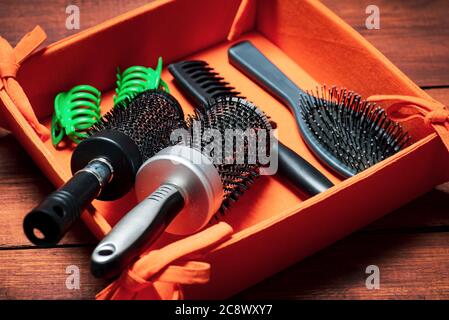 Hairbrushes and combs in a wooden box closeup. Hair style and beauty abstract Stock Photo