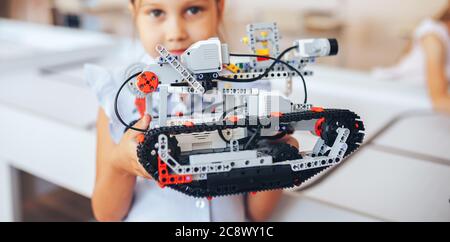 Schoolgirl holding constructor robot in robotics class Stock Photo