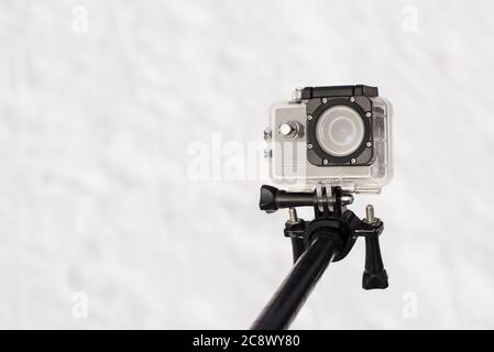 Isolated closeup shot of a small portable action camera on a stick on a white background Stock Photo