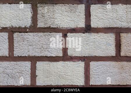 Background texture of white stone sand lime brick wall pasted with red colored cement. Stock Photo