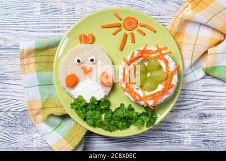 Funny toast in a shape of chick and nest with eggs, sandwich for kids Easter idea, top view Stock Photo