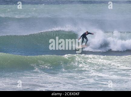 Garrettstown, Cork, Ireland. 27th July, 2020.A surfer rides the wave in turbulent storm like conditions at Garrettstown, Co. Cork, Ireland. - Credit; David Creedon / Alamy Live News Stock Photo