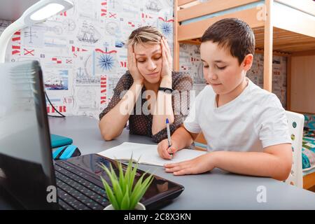 Woman working from home while son using digital tablet. Freelance job Stock Photo