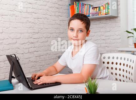 Schoolboy studying homework math during her online lesson at home ...