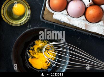Beaten egg yolks in a bowl on a dark background. Stock Photo