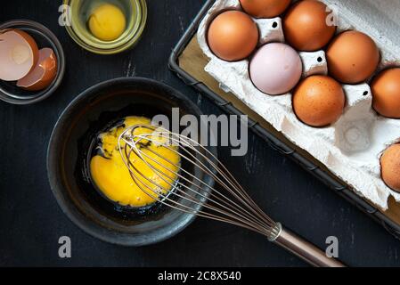 Beaten egg yolks in a bowl on a dark background. Stock Photo