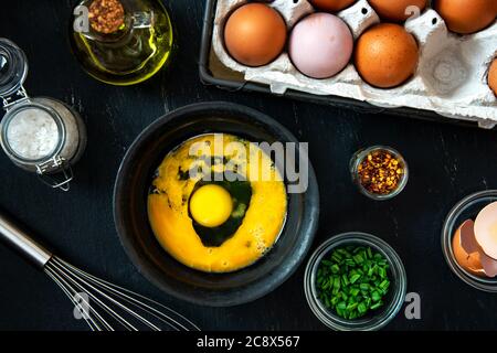 Beat eggs in a bowl, and ingredients for making an omelette with green onions. Stock Photo