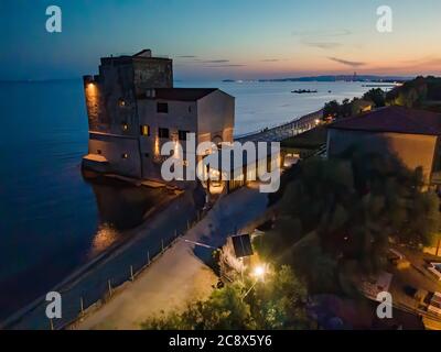 Night aerial view of medieval tower along the shoreline. Stock Photo