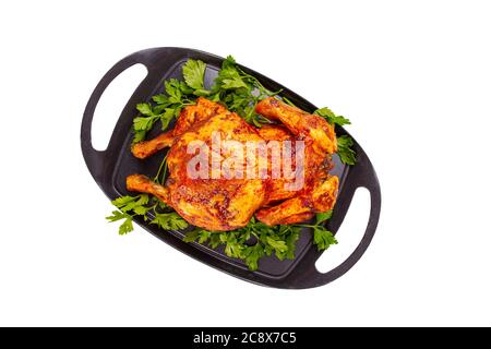 Flat lay of oven baked whole chicken on iron plate, white background Stock Photo