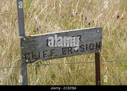 Sign by high cliff at Beachy Head on English south coast: 'Danger, Cliff Errosion', England Stock Photo