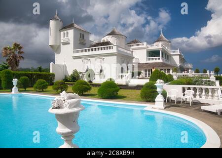 A very ornate white painted house and swimming pool in Jamaica, The Caribbean Stock Photo