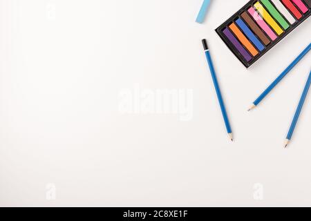 Colorful wax crayons and pencils isolated on white background. Copy space. Top view. Stock Photo