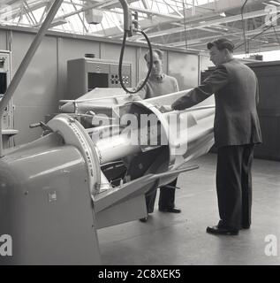 1950s, historical, Aviation, testing facility. Two engineeers with an early prototype jet turbine engine at Short Bros, Belfast, N. Ireland, UK. Stock Photo