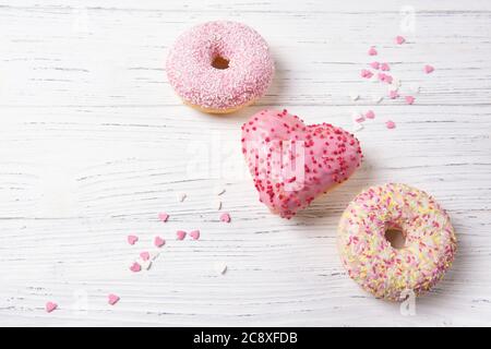 Donuts in a shape of the heart on a wooden background, Mothers day card Stock Photo