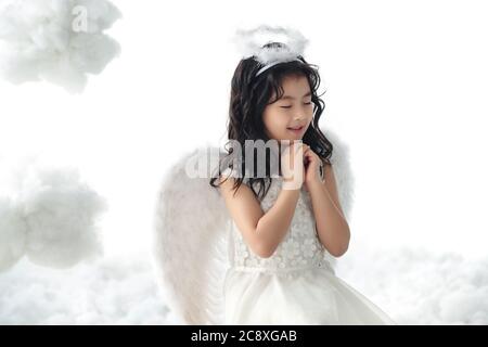 Happy little angel praying Stock Photo