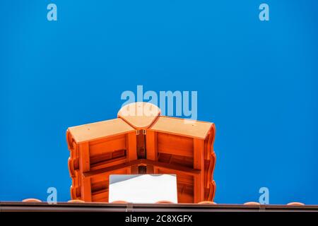 Brown tile roof under blue sky. The photo is divided on two part. One part is a roof made of clay tiles and the other is a blue sky. Brown surface of Stock Photo