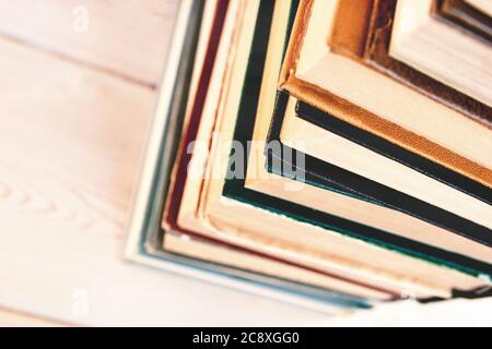 Stack of old used books on wooden table. Pile of vintage old hardback books. Stock Photo