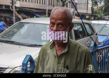 Kolkata, India. 27th July, 2020. An old man, who's face is half covered by a mask, walks on a street of the city, in this pandemic situation. Although his face is covered, his nose is not covered at all. (Photo by Jit Chattopadhyay/Pacific Press) Credit: Pacific Press Media Production Corp./Alamy Live News Stock Photo