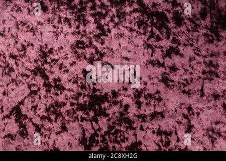 The fabric texture is plush in magenta color, laid out smoothly. Stock Photo