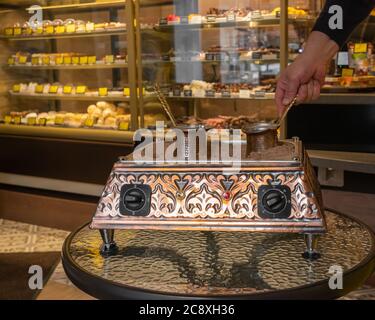 Metal coffee maker and a pattern of coffee beans in the shape of a circle  on a gray background with Stock Photo by Artjazz