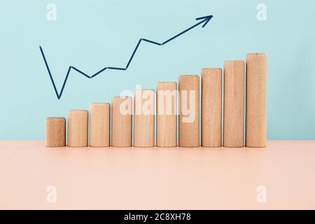 Business growth concept on blue background. Wood block increasing chart. Stock Photo