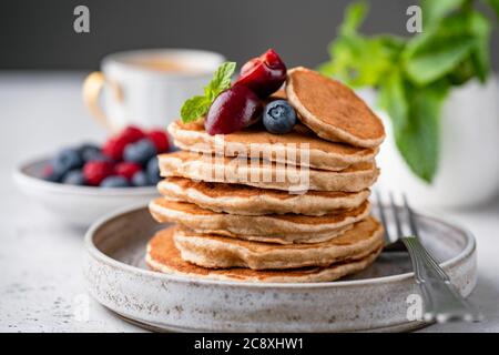 Vegan gluten free buckwheat pancakes with berries on a plate. Healthy pancakes Stock Photo