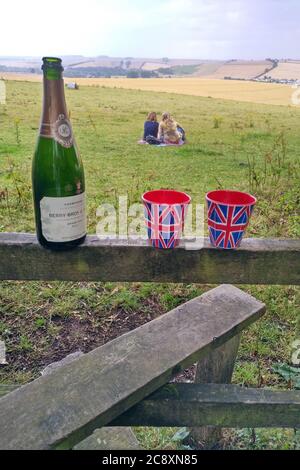 Birthday celebrations with Champagne and Union Flag cups on a country stile in the Wylye Valley near Wilton, Wiltshire UK 2020. Stock Photo