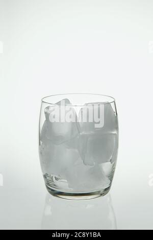 Photograph of a glass full of ice cubes on a light background. Stock Photo