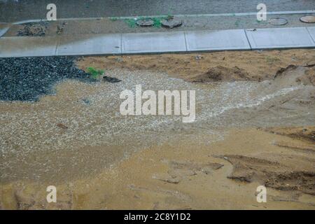 Street flooded heavy rain drops falling on city street during downpour Stock Photo