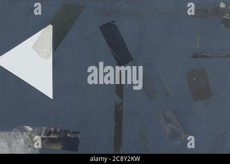 Adhesive tape stains and stickers on weathered metal surface. Abstract grunge background with copy-space. Stock Photo