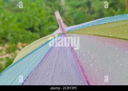 Raindrop or water drops on rainbow umbrella surface. Splash, rain Stock Photo