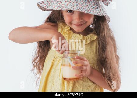 Beautiful little girl eating tasty cream dessert portrait isolated on white background Stock Photo